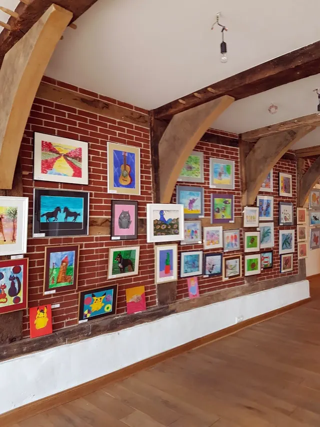 Kinderbilder an einer Backsteinwand in einer Ausstellung