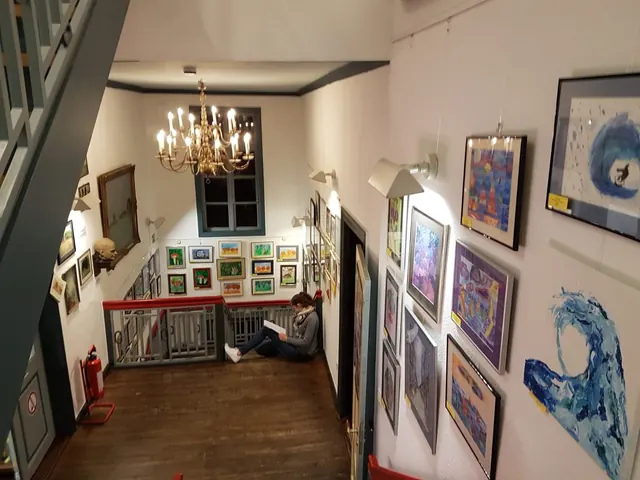 Ausstellung von Schülerbildern in einem historischen Flur