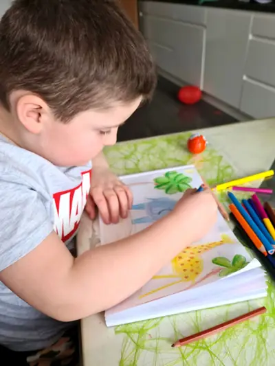 Junge malt mit Buntstiften