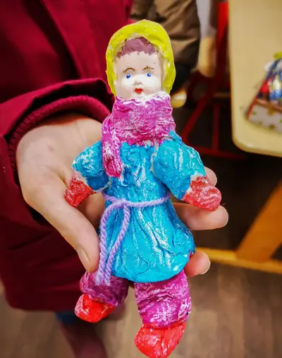 Puppe aus Modelliermasse im blauen Mantel