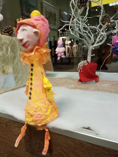 Figur aus Modelliermasse im gelben Mantel