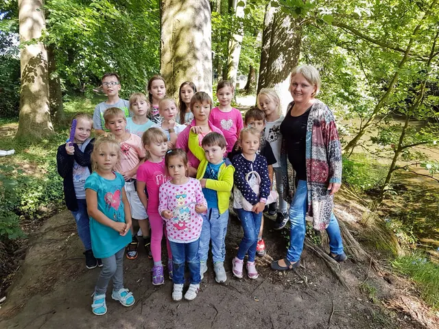 Vorschulgruppe mit Lehrerin bei einem Ausflug in den Wald